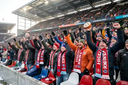 Supporters de rugby en écharpes devant un stade