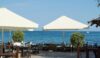 Tables and umbrellas at the seaside restaurant on a Sunny summer day